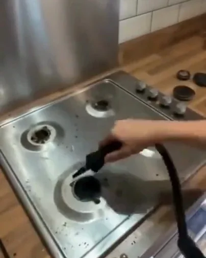 Le nettoyeur vapeur passé autour des reliefs de cuisson d’une plaque